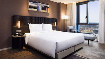The 400 rooms include Junior and Executive Suites with living areas, Deluxe Triple Rooms for families, and select rooms with Seoul Botanic Park views.